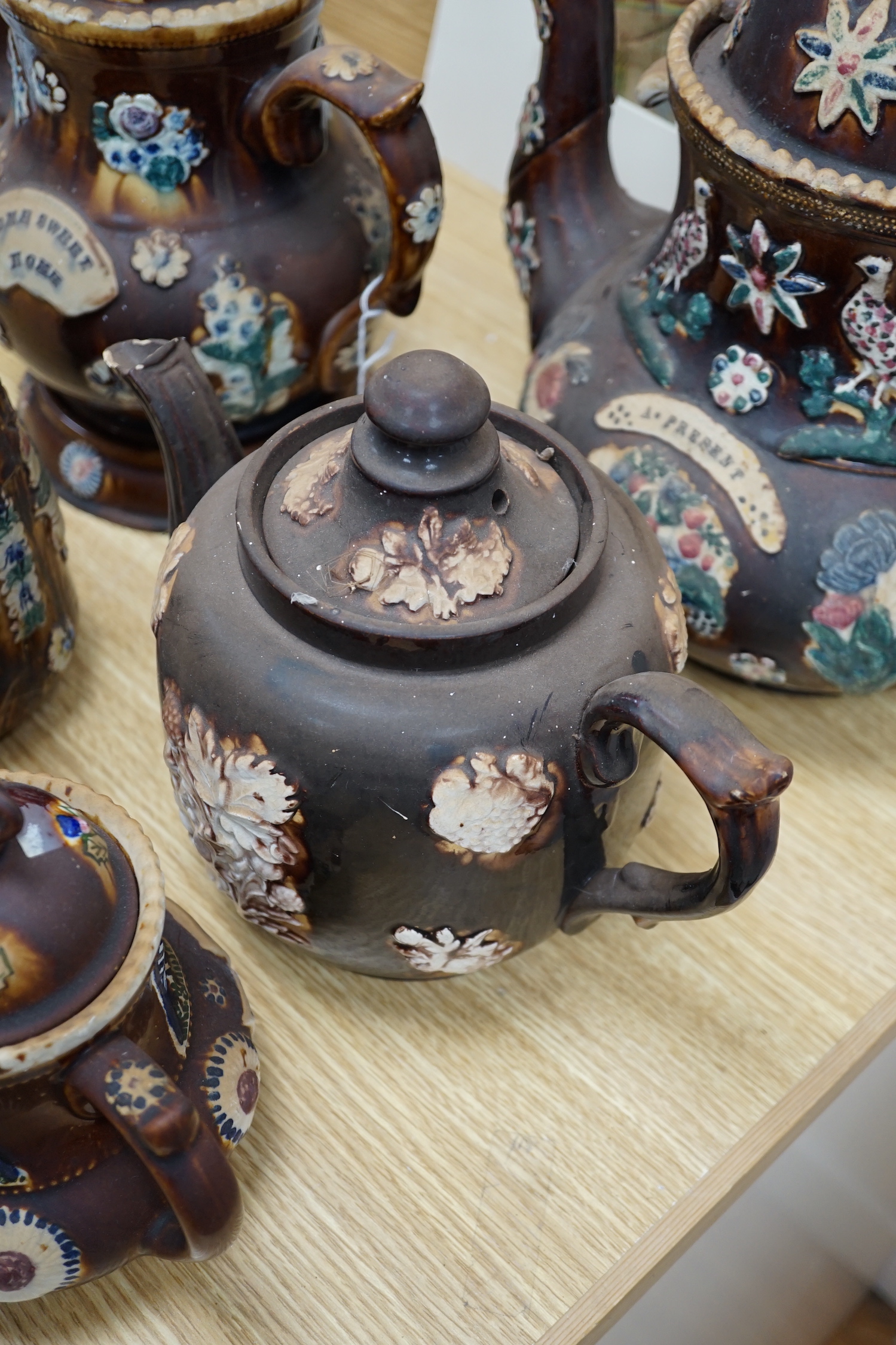 A Measham Barge ware glazed pottery teapot, decorated in relief, 28cm wide